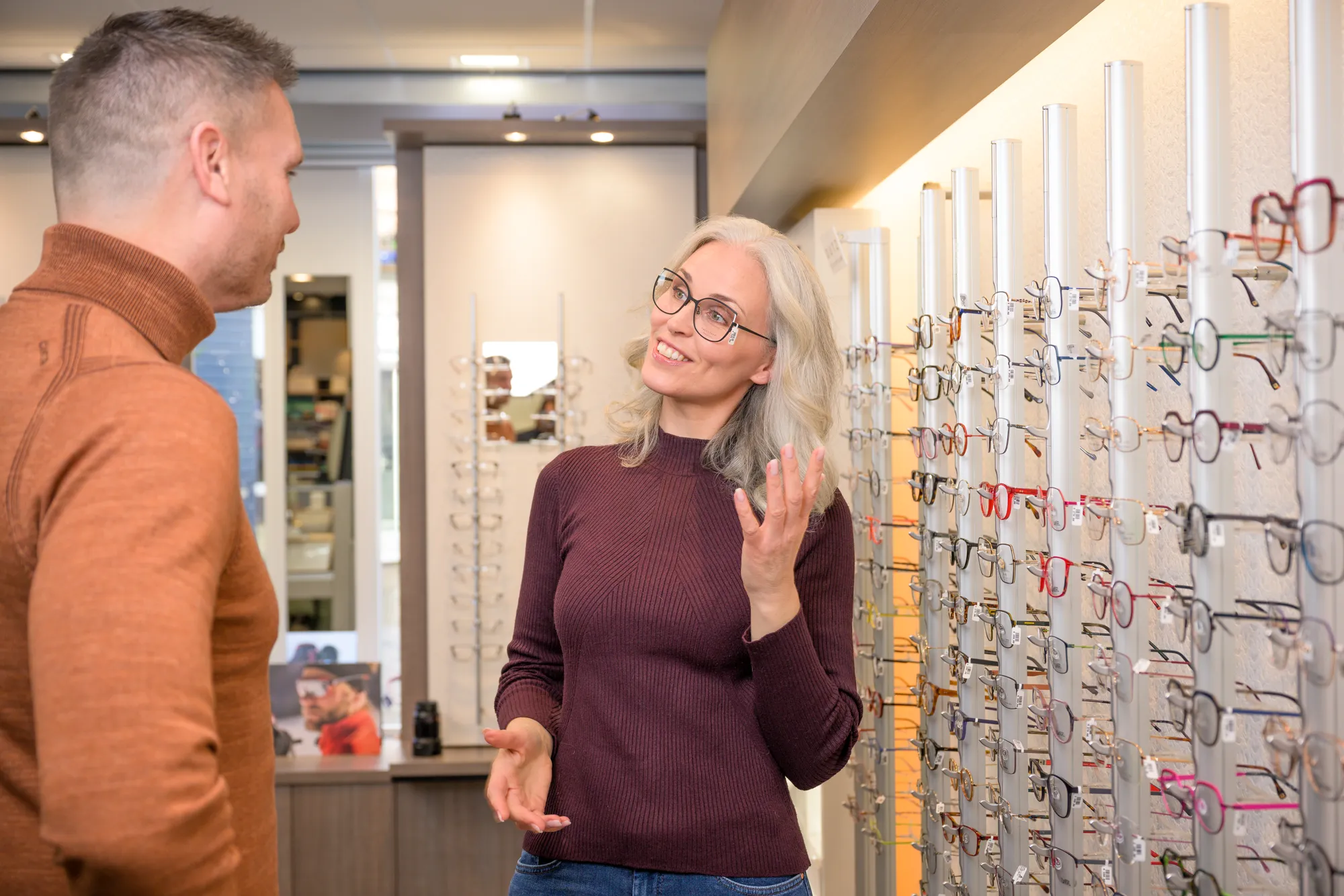 Klant past een montuur voor de spiegel in de optiek van Von Oy