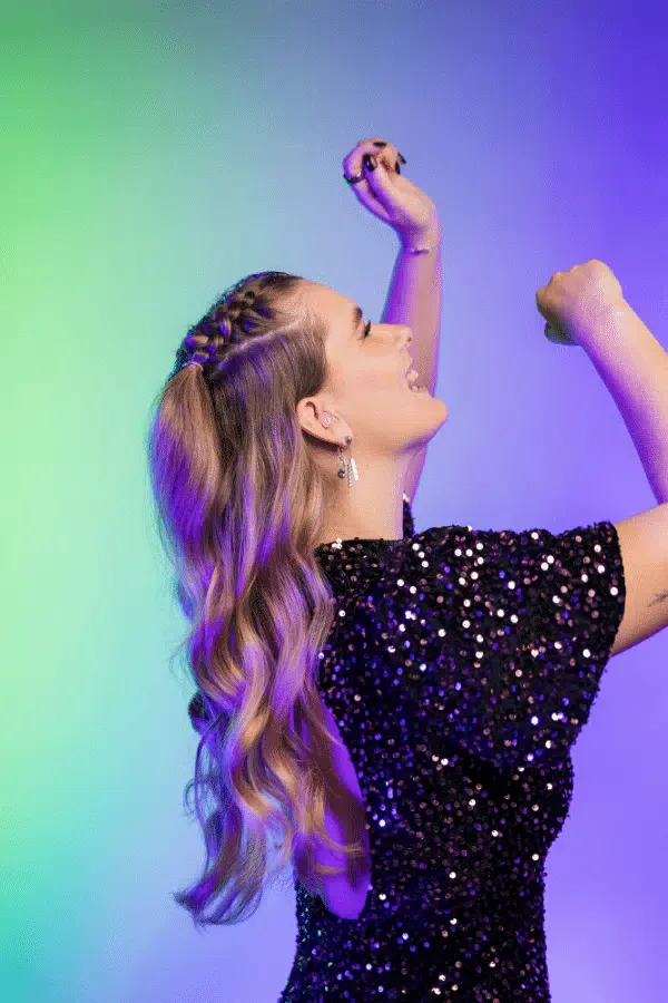 Vrouw danst in paars licht, met gehoorbescherming van Pluggerz