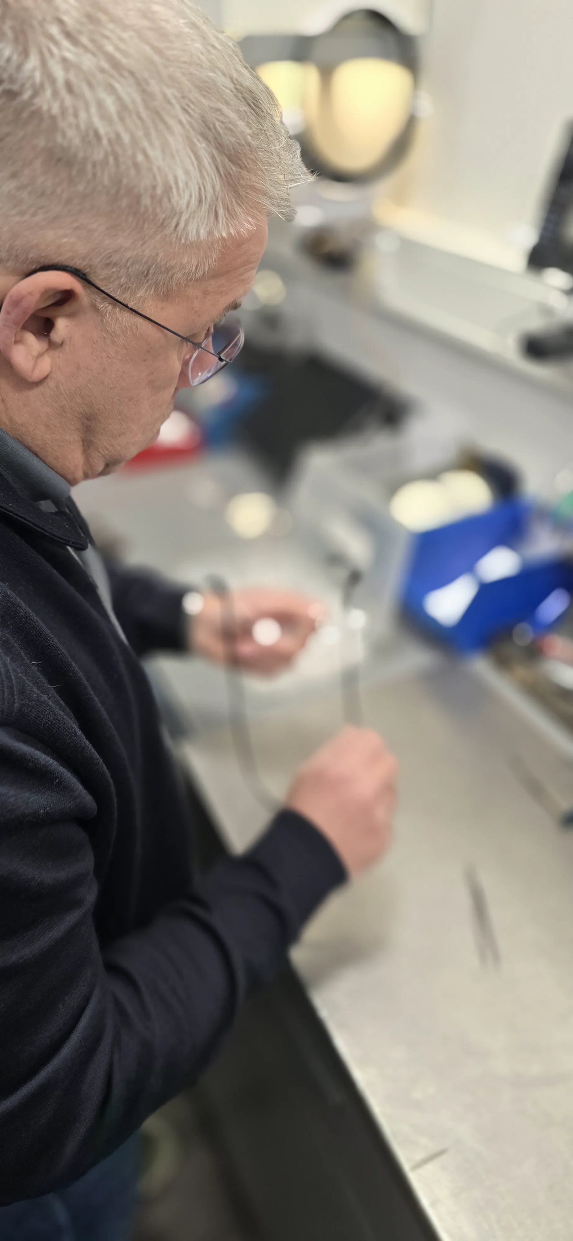 Cris stelt een bril bij en vervangt kleine onderdelen in de winkel